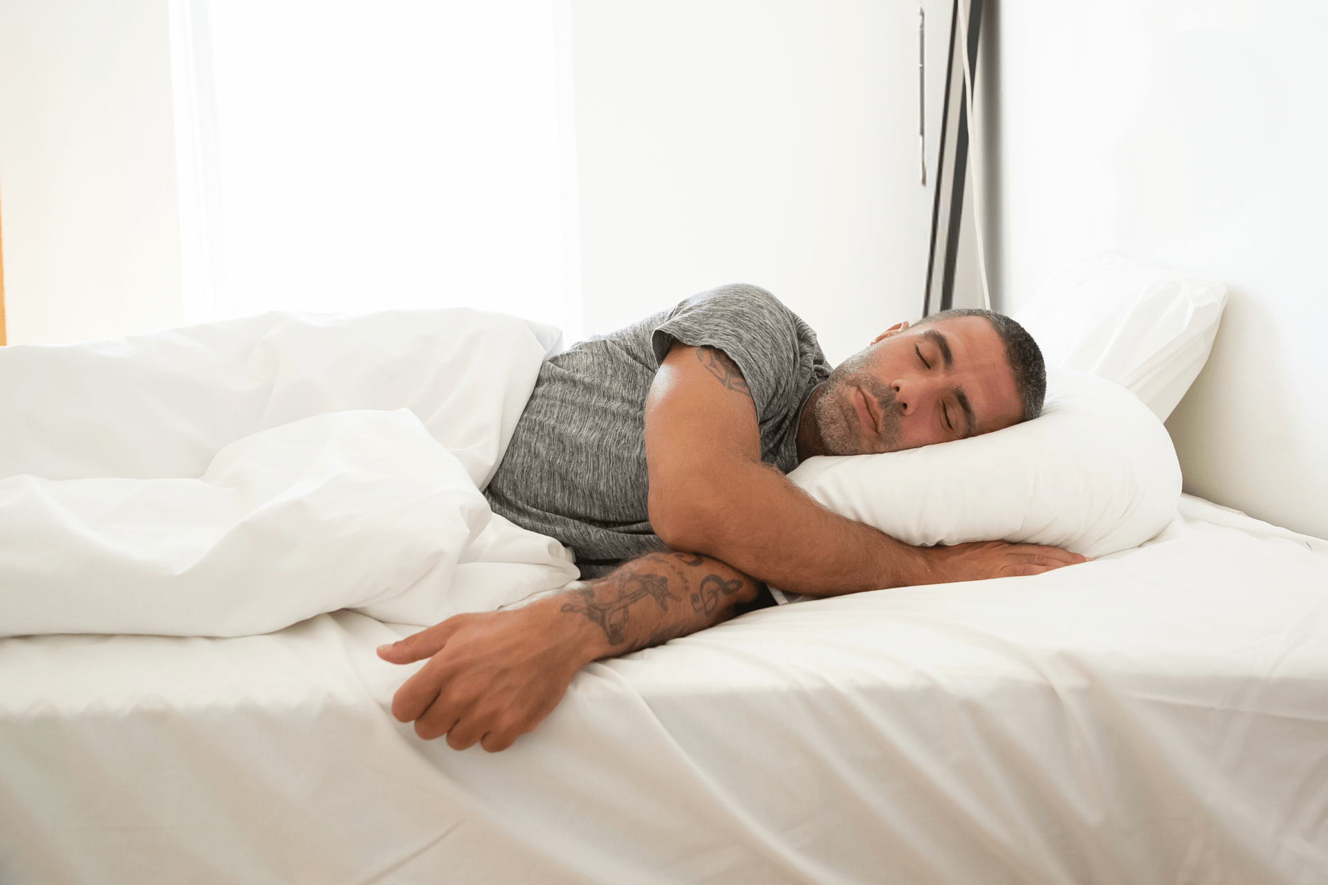 Man with Tattoos Laying in Bed Sick